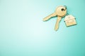 Close up of keys with house keychain on blue surface background with mock up place. Real estate and property concept. Royalty Free Stock Photo