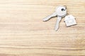 Close up of keys with house keychain on wooden surface background with mock up place. Real estate and property concept. 3D