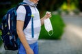 Close-up of kid boy with medical mask and backpack or satchel. Schoolkid on way to school. child outdoors. Back to