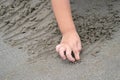 Close up kid`s hand and fingers, play and learn at the beach