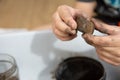 Close-up kid`s hands polishing a tiger eye rock or mineral. children science concept