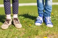 Close up of kids legs in shoes on grass outdoors