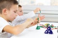 Close-up of kids playing board game while sitting at the table at home, magnetic sticks and balls for child development