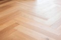 A close-up of a kitchen floor tile in a rough, zigzag pattern. The tile is a warm brown