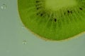 Close-up of kiwi fruit in liquid with bubbles. Slice of green ripe kiwi fruit in sparkling water. Juicy kiwi fruit in Royalty Free Stock Photo