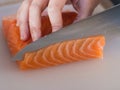 Close-up of a knife cutting a piece of salmon. Royalty Free Stock Photo