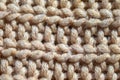 Close-up knit stitching beige close-up, handmade woolen fabric.