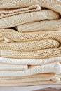 Close-up of knitted clothes in warm beige shades with a different pattern of the fall / winter season texture, background.