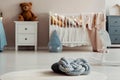 Close-up on a knot cushion with dots pattern lying on a white rug. Blurred baby room in the background. Real photo Royalty Free Stock Photo