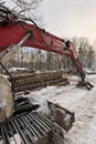 Close up of Knuckleboom Log loader with Freshly Harvested and piled timber logs