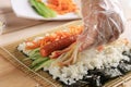 Close Up Korean Female Making Gimbap, Korean Roll Rice with Sausace, Kyuri, Carrot, and Crabstick