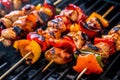 Close-up of Kung Pao chicken skewers on a grill with charred red bell peppers and brushed with sweet and spicy sauce