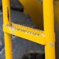 Close up of the ladder with peeling yellow paint of a construction machinery Royalty Free Stock Photo