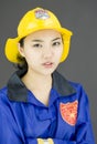 Close up of a lady firefighter wearing yellow helmet and blue fire protection suit