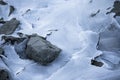 Close up on lake bank rocks surrounded with cold frozen ice plaques on groundfloor Royalty Free Stock Photo