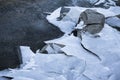 Close up on lake bank rocks surrounded with cold frozen ice plaques on groundfloor