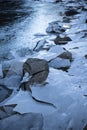 Close up on lake bank rocks surrounded with cold frozen ice plaques on groundfloor Royalty Free Stock Photo