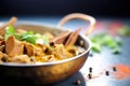 close-up of lamb korma, visible cardamom pods, backlit effect