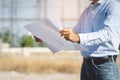 Close up land inspector checking blueprint for industry construction