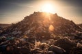 close-up of a landfill's towering pile of waste, with the sun shining down on it