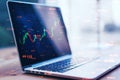 Close up of laptop with abstract candlestick forex graph and bid data numbers on blurry desktop background. Finance, technology, Royalty Free Stock Photo