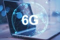 Close up of laptop with abstract globe 6G hologram on blurry background. Technology, data and future concept. Royalty Free Stock Photo