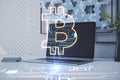 Close up of laptop with abstract glowing bitcoin circuit hologram on office workplace background. Cryptocurrency and finance