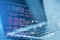 Close up of laptop with abstract html code on creative city background. Coding and programming concept.