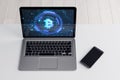 Close up of laptop with bitcoin on screen. White desk with smartphone. Crypto and money concept.