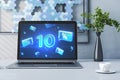 Close up of laptop with blue 50% sale on screen on desktop with coffee cup, plant and painting. Online shopping and money concept Royalty Free Stock Photo