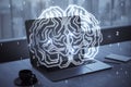 Close up of laptop computer on desktop with coffee cup and glowing human brain hologram on screen and blurry background. Neurology