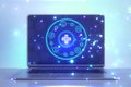 Close up of laptop with creative round medical interface with cross and other icons on blue background. Healthcare and innovation Royalty Free Stock Photo