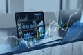 Close up of laptop at desk with glowing candlestick forex chart on blurry background. Trade, finance and technology concept. Royalty Free Stock Photo