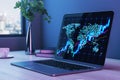 Close up of laptop on desktop with coffee cup, decorative plant and glowing candlestick forex chart map on blurry background with