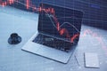 Close up of laptop on desktop with coffee cup, notepad and falling red crisis forex chart on screen. Recession, trade and downfall Royalty Free Stock Photo