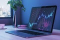 Close up of laptop with glowing candlestick forex chart on screen placed on modern workplace background with coffee cup and city