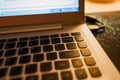 Close-up of laptop keyboard with focus on Backspace button and highlighted with warm evening light