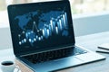 Close up of laptop at office desk with coffee cup and creative business chart, map and index on blurry window city view backdrop. Royalty Free Stock Photo