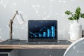 Close up of laptop at polygonal workplace with growing coins stack hologram on concrete wall background. Saving money concept Royalty Free Stock Photo