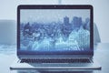 Close up of laptop screen with abstract glowing blue business graph on blurry city background. Financial growth, market and stock