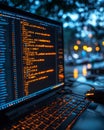 Laptop screen displaying programming code with a vivid orange backlit keyboard at night, soft bokeh background. Royalty Free Stock Photo
