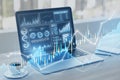 Close up of laptop at table with glowing candlestick forex chart on blurry background. Trade, finance and technology concept. Royalty Free Stock Photo