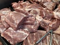 Close up of large chunks of raw pork meat in refrigerator on supermarket counter