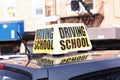 Close up of large driving school sign on the roof of a practice car in a busy city street Royalty Free Stock Photo