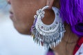 Close-up of large earrings on the ears of a ethnic Hmong woman on the street in mountain village Sapa, North Vietnam