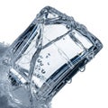 Ice cube appears transparent with a bluish tint, encased in frost, Royalty Free Stock Photo
