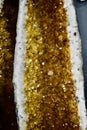 Close-up of a large gold-colored heated crystal rock containing a plethora of sparkling gems