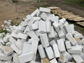Close up of large pile of white bricks on ground. Building materials on construction site outdoor. Concept of Royalty Free Stock Photo