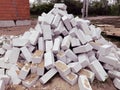 Close up of large pile of white bricks on ground. Building materials on construction site outdoor. Concept of Royalty Free Stock Photo