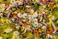 Close up of large portion of mixed seafood cooked with vegetables, available for sale at a street food market, selective focus